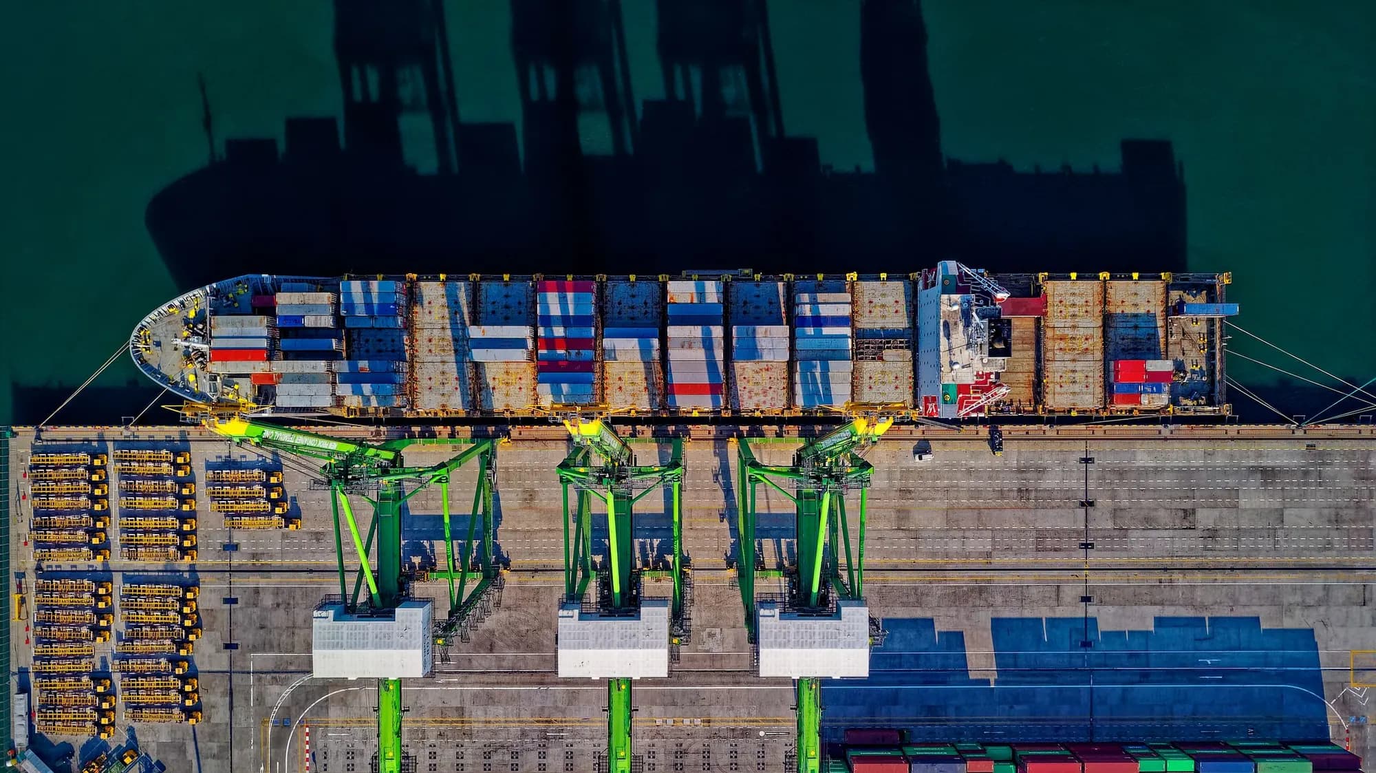 Aerial view of gantry cranes working a berthed container ship